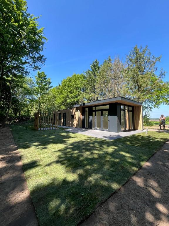 a house with a large yard in front of it at Chalet Aazicht Drenthe met Hottub in Zeyen