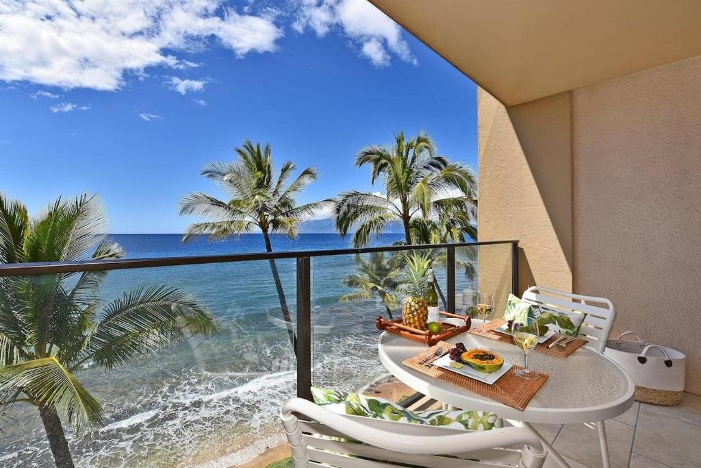 a table and chairs on a balcony with a view of the ocean at Mahana 602 · MA 602 Kaanapali OceanFront Studio Ocean View Pool in Kahana