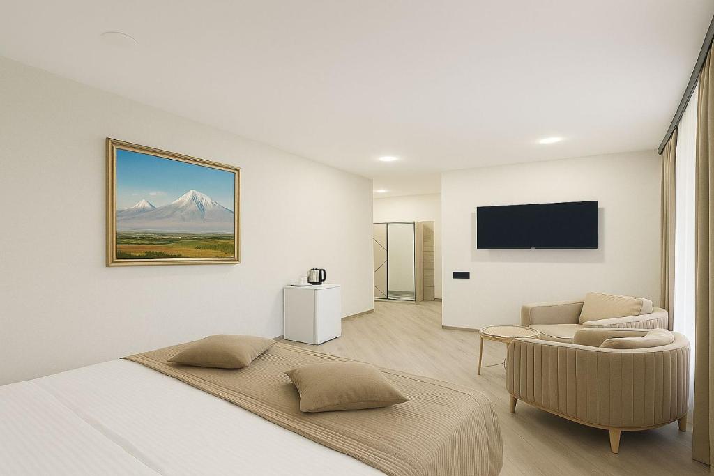 a white living room with a couch and a tv at RR Boutique Hotel in Yerevan