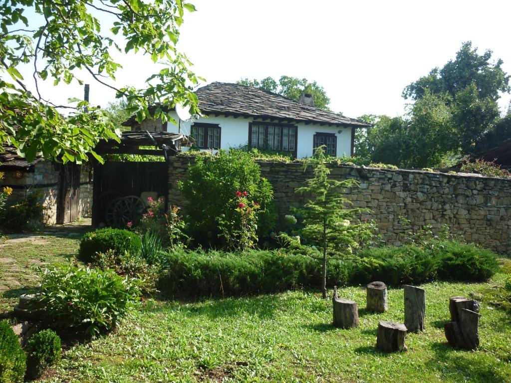 einen Garten mit einer Steinmauer und einem Haus in der Unterkunft Guesthouse Peyna in Peyna