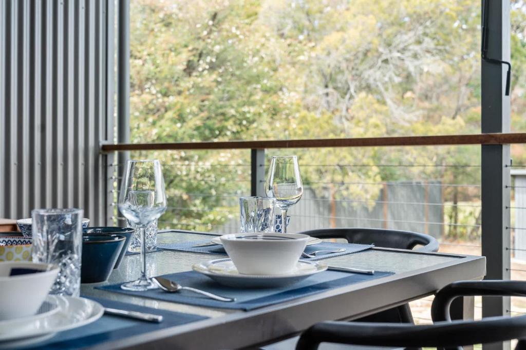 une table avec des verres et des assiettes au-dessus dans l'établissement Coastal Retreat, à Kioloa