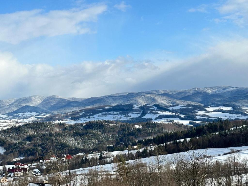 a view of a snowy mountain with mountains in the background at Domki przy szlaku Szczebel in Lubień