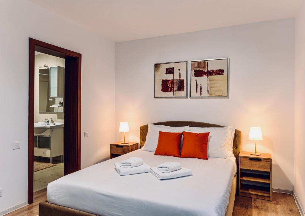 a bedroom with a bed with two towels on it at Vila LINA in Braşov