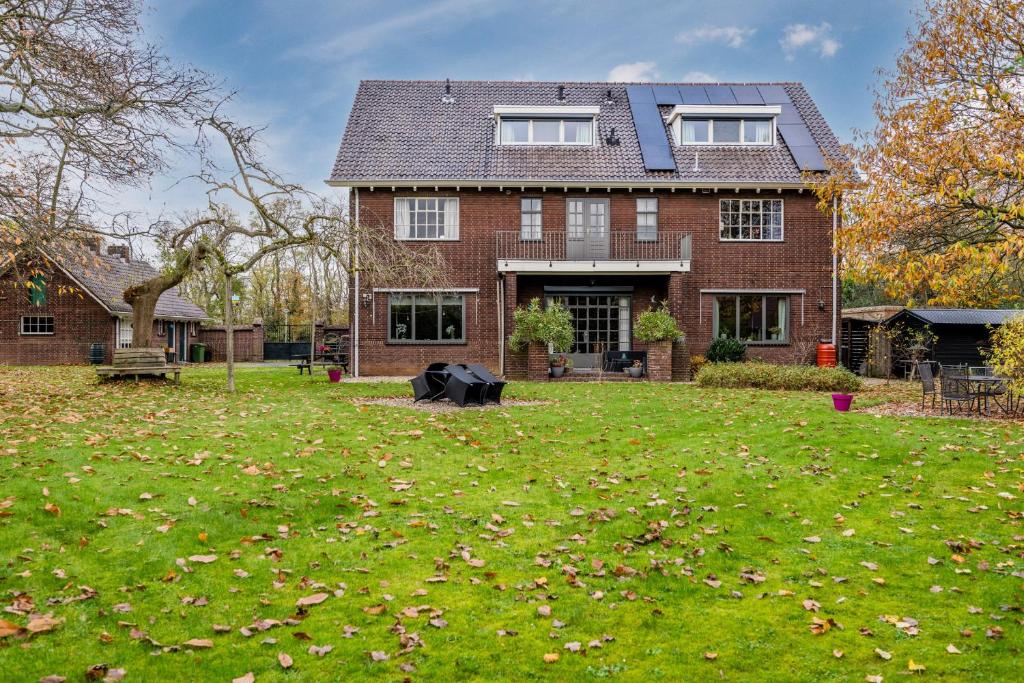 een huis met een tuin met bladeren op het gras bij BergOpwaerts in Sint Odiliënberg