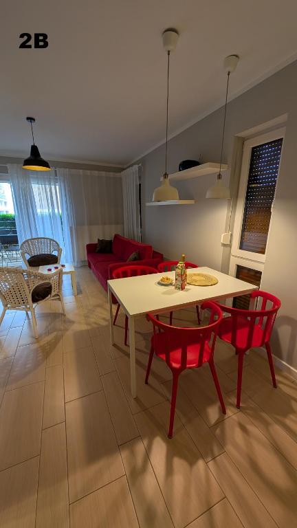 a living room with a table and red chairs at Apartamenty Morze Wygody in Międzywodzie