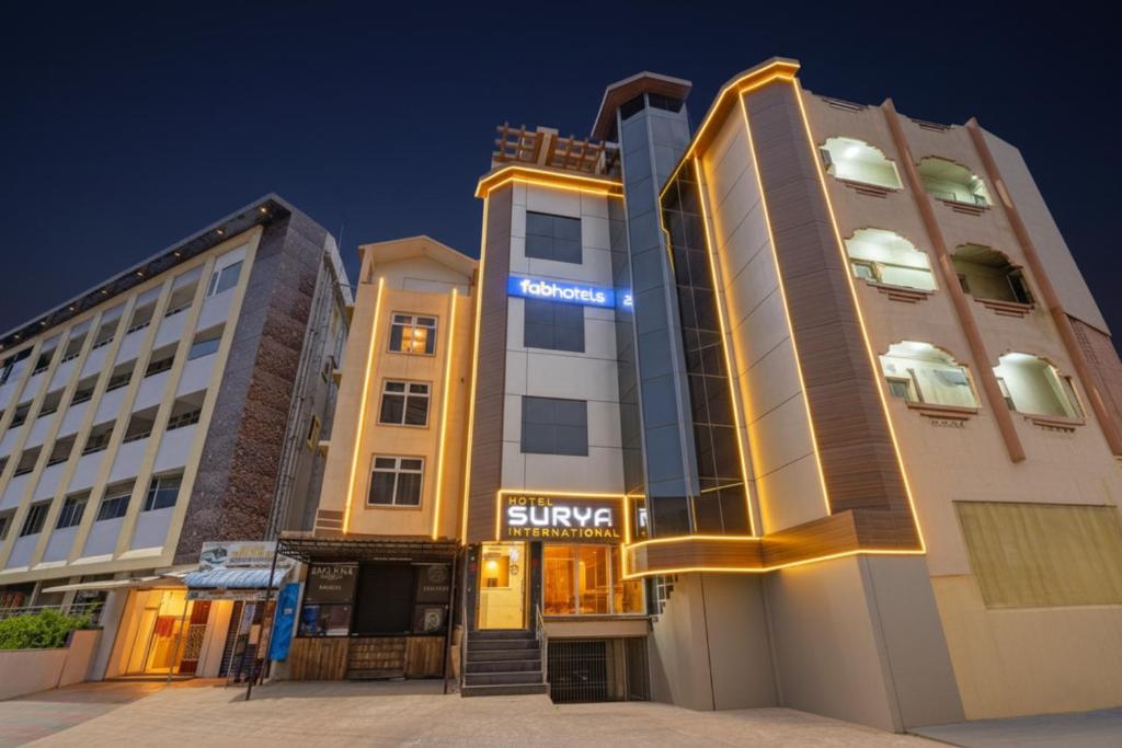 un hôtel avec une enseigne sur le côté d'un bâtiment dans l'établissement FabHotel Surya International, à Nellore