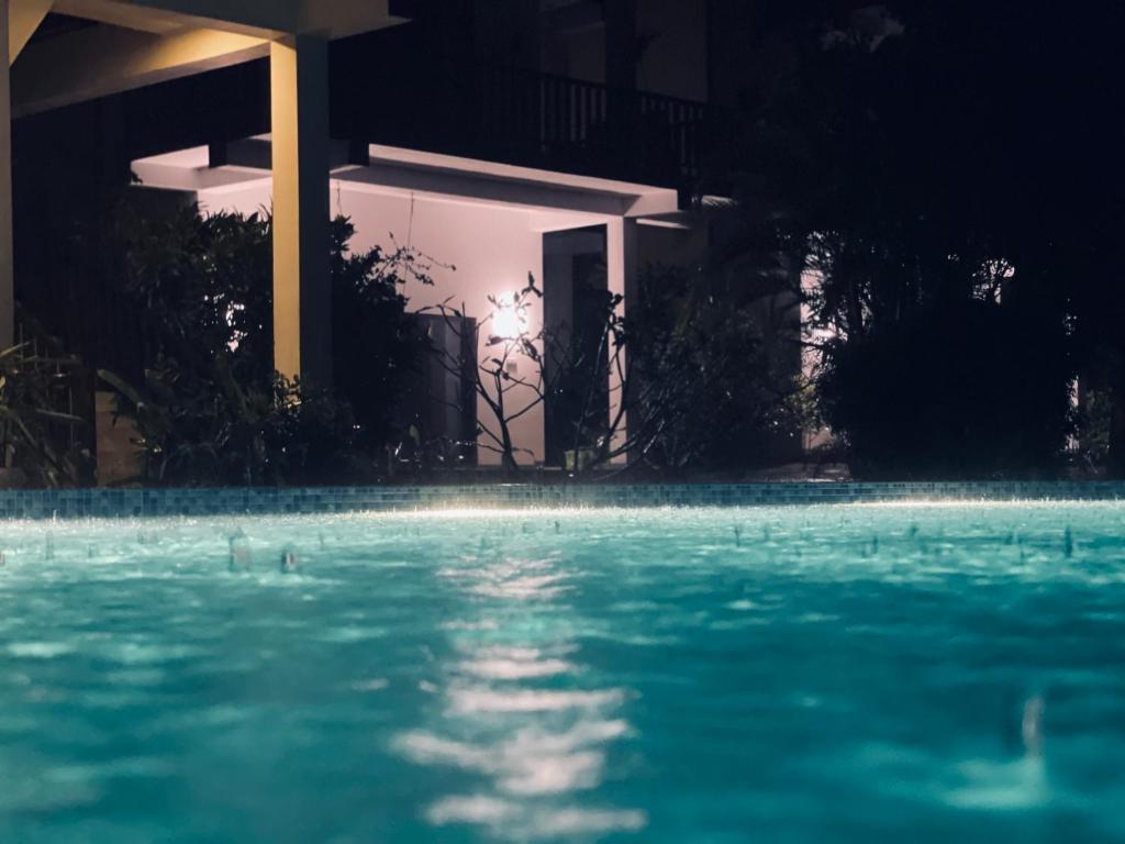 une piscine devant une maison la nuit dans l'établissement Ashansa Lagoon Resort, à Tangalle
