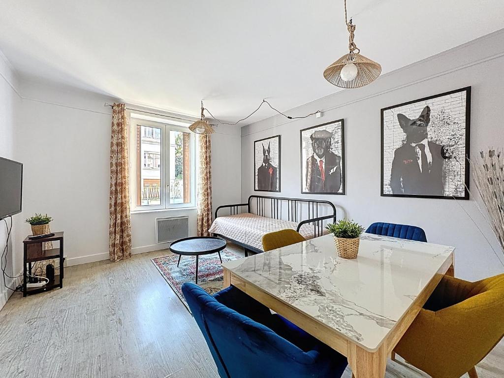 un salon avec une table et des chaises dans l'établissement Rue Bien Assis avec jardin terrasse, à Clermont-Ferrand