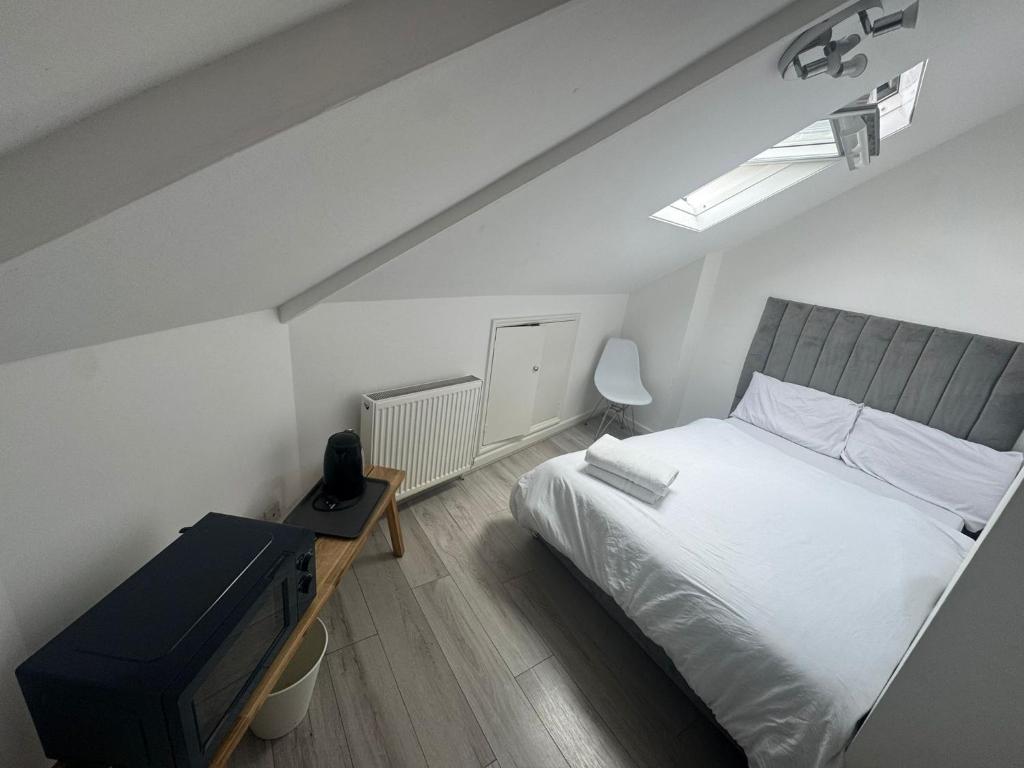 une chambre avec un grand lit blanc et un bureau dans l'établissement London Duo & Quad Rooms in Zone 2 - Willesden Green, à Londres