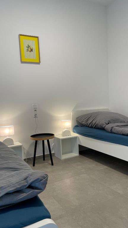 une chambre avec deux lits et une table dans l'établissement Frisch saniert, Moderne Ferienwohnungen für 1 bis 37 Personen, Warme Weihnachten, à Böbingen an der Rems