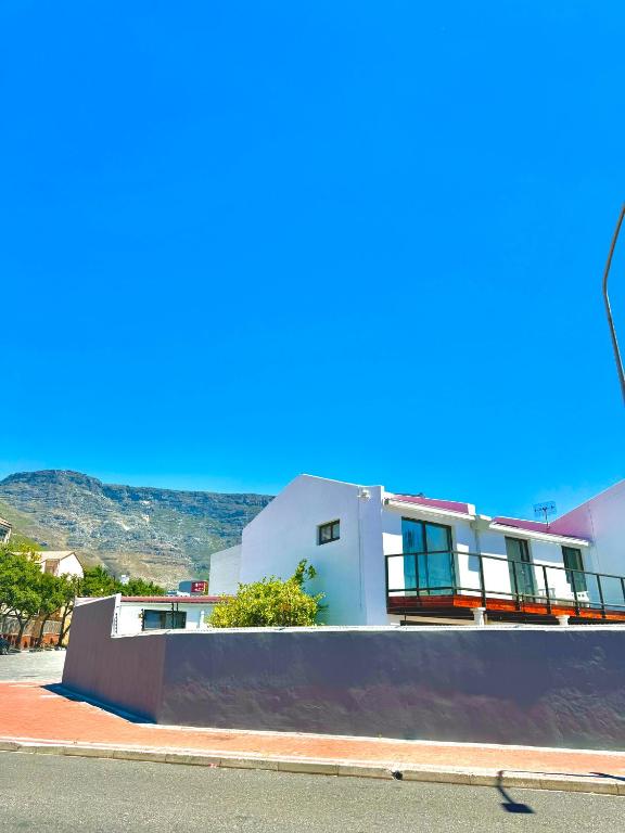 a white building with a wall next to a street at The White House - Zonnebloem in Cape Town