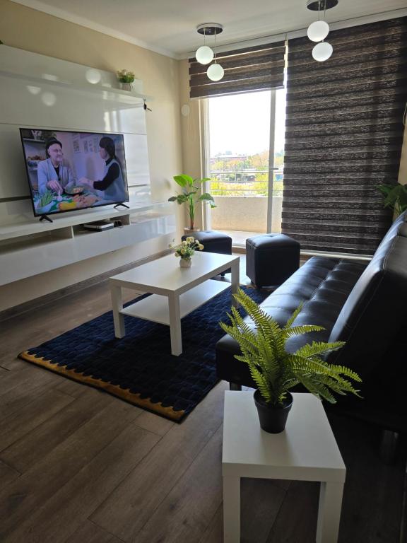 ein Wohnzimmer mit Sofa und Fernseher in der Unterkunft Fabuloso Amplio Departamento 3 dorm Parcking y Wifi in Rancagua