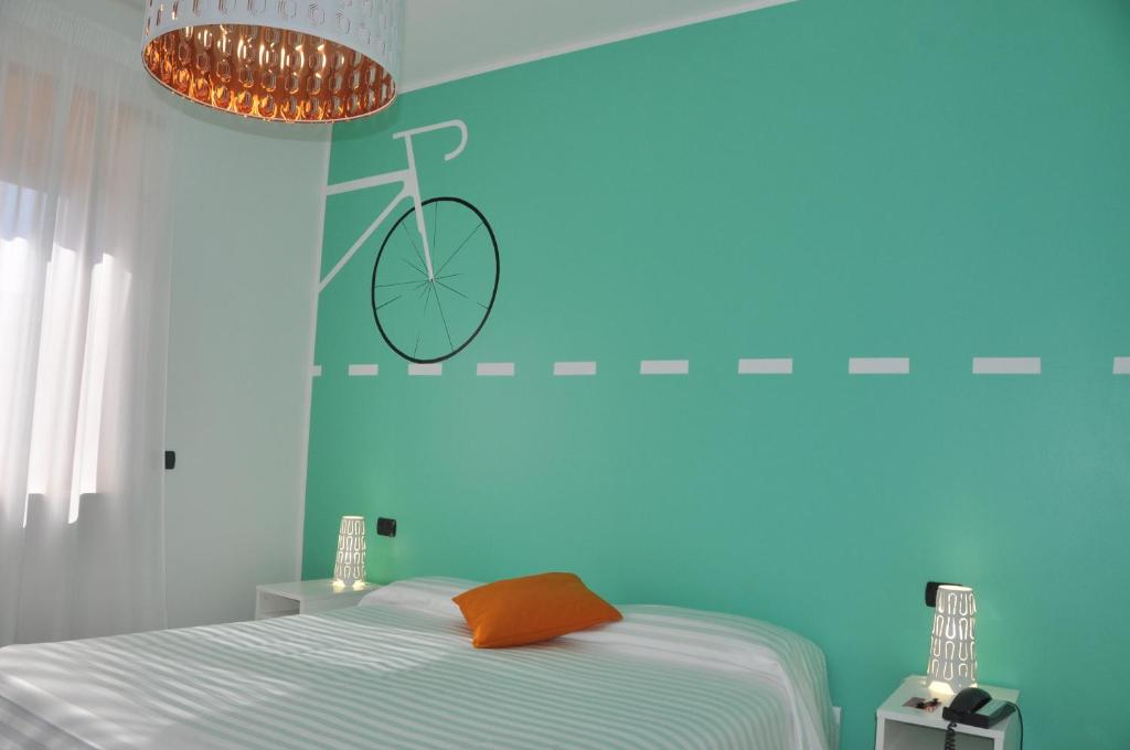 una camera da letto con una parete blu con una bicicletta sopra di Lo Scoiattolo Piedmont Bike Hotel a Pralormo