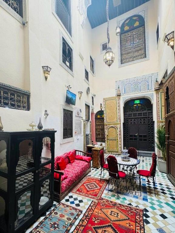 a living room with a red couch and a table at Riad Panoramik in Fez