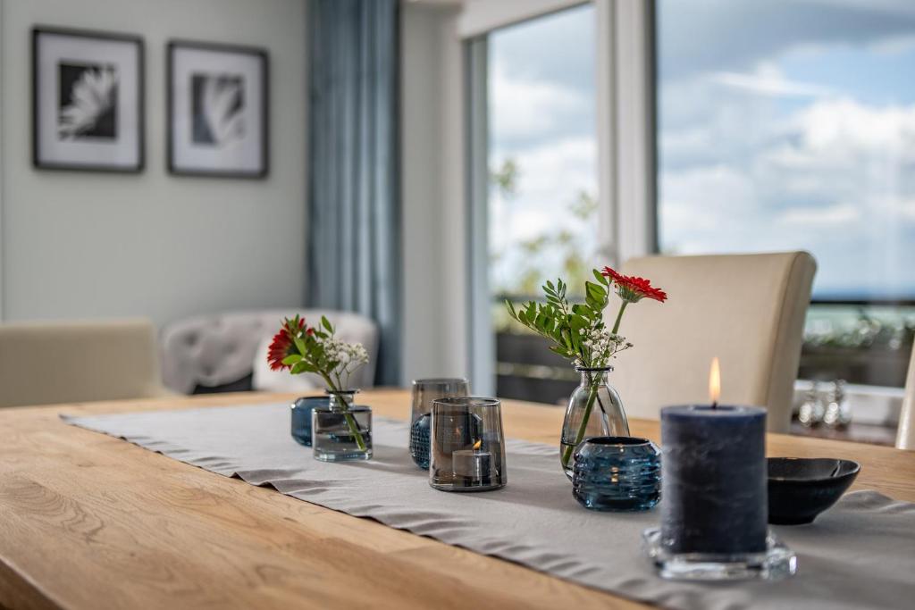- une table avec une bougie et des vases avec des fleurs dans l'établissement Baden-Chalet, à Brombach