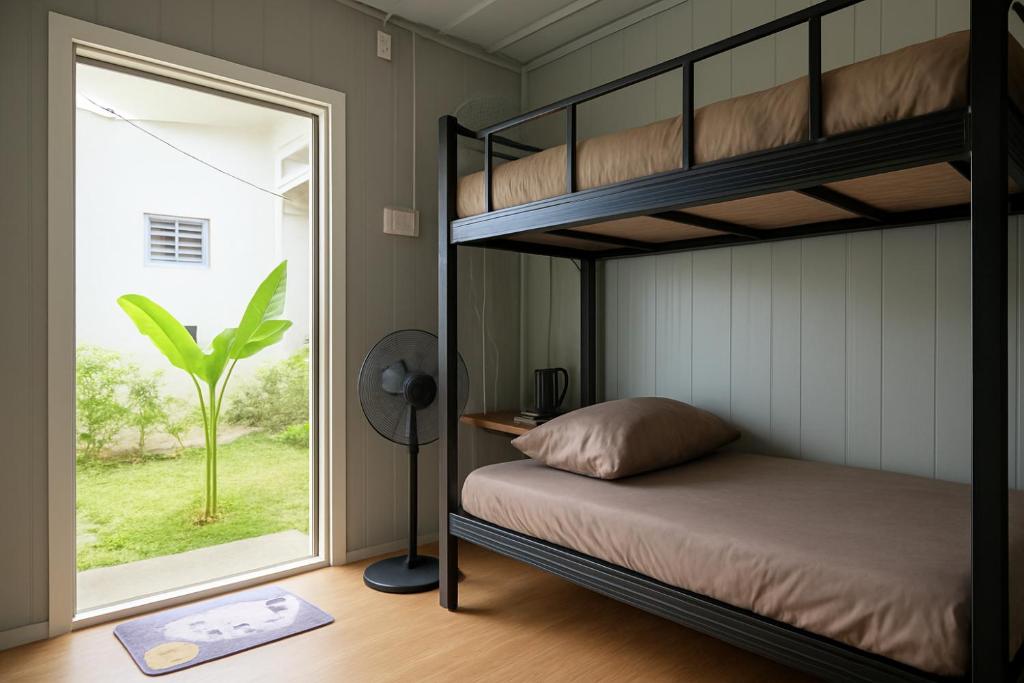 une chambre avec un lit superposé et une fenêtre dans l'établissement Inap Cabin, à Teluk Bahang