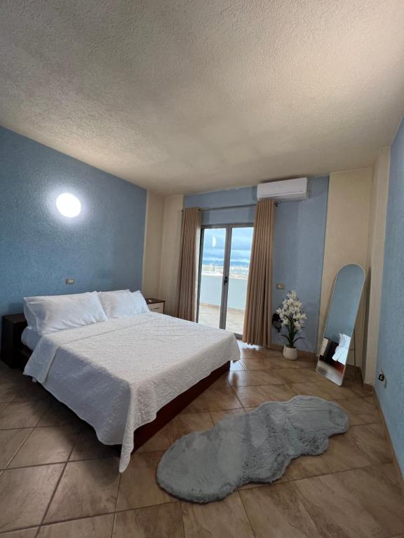 una camera da letto con un letto grande e una grande finestra di Hana's Apartment a Durrës
