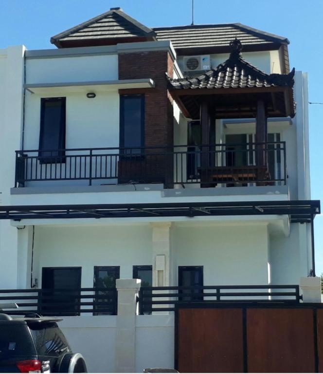 a house with a balcony on the side of it at Chandra's guest house in Pesanggaran