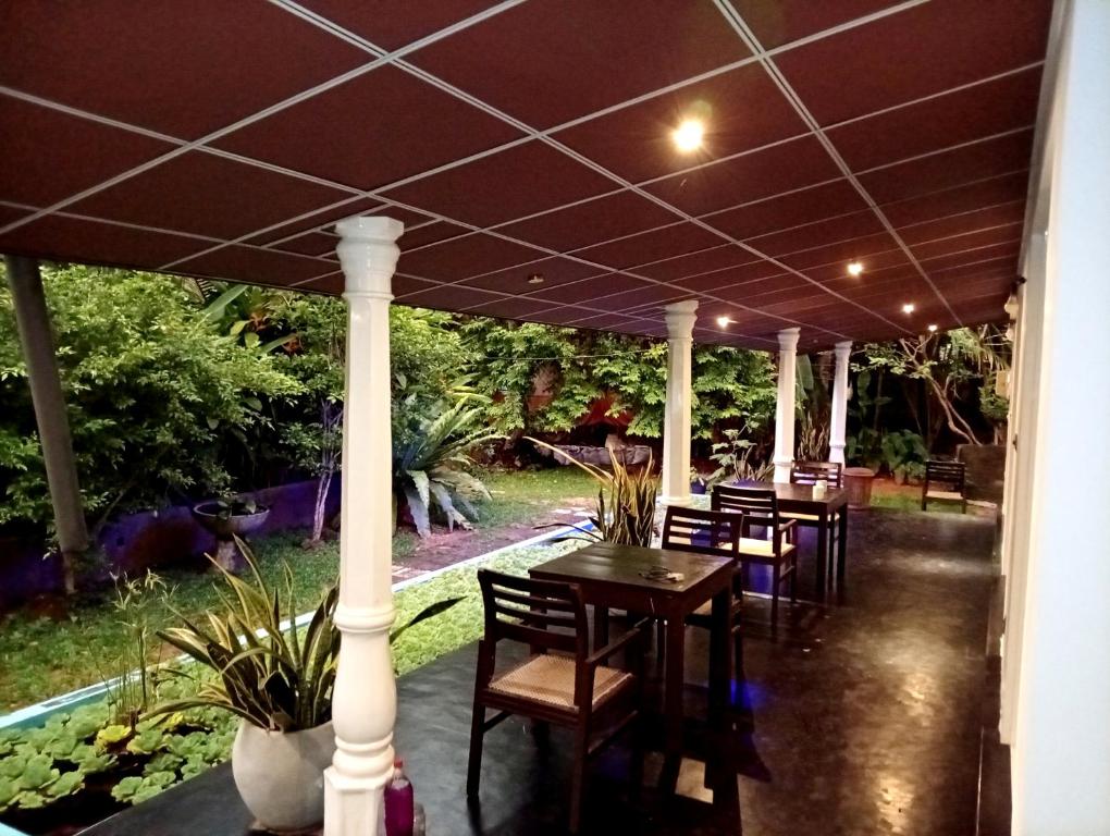 une terrasse avec des tables et des chaises sous un parasol dans l'établissement Happy Three Holiday Homes, à Hikkaduwa
