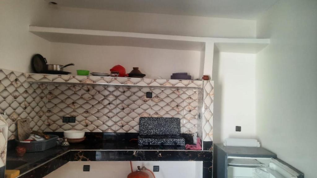 Una cocina con encimera negra en una habitación. en sweet area, en Mirleft