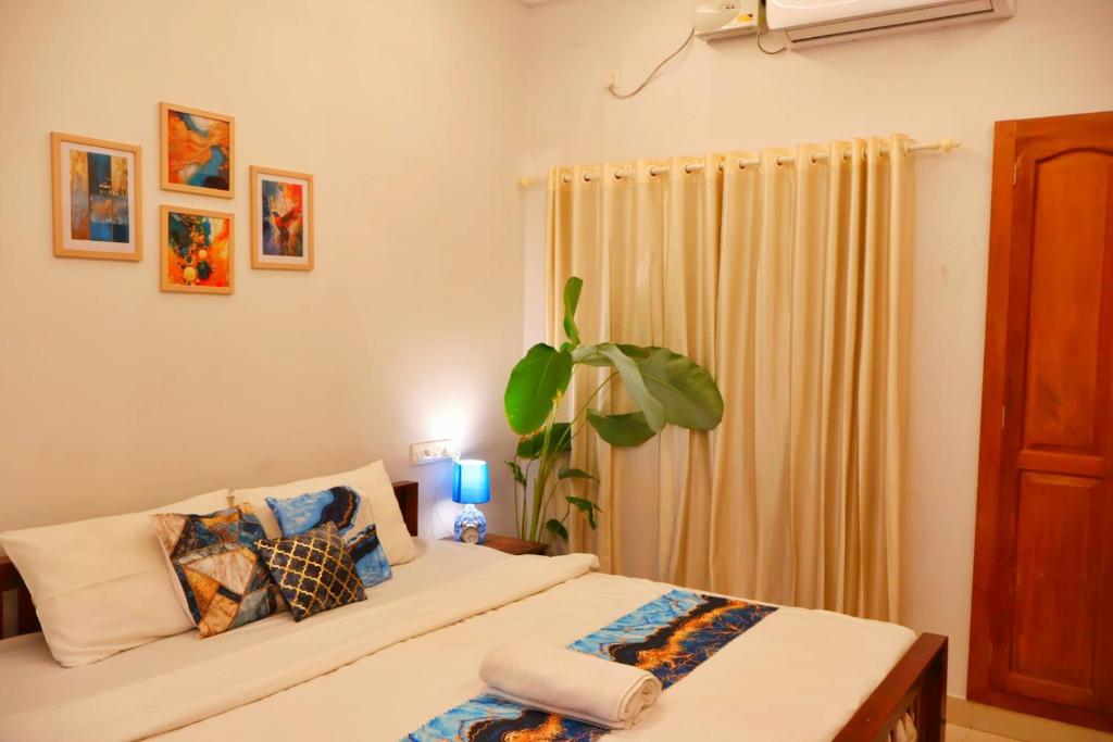 a bedroom with a bed and a potted plant at PALM GROVE By D2V in Cochin