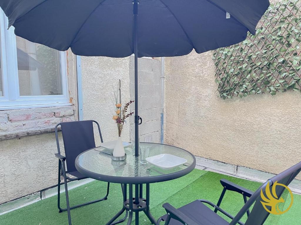 a table and chairs with a blue umbrella at Le Spacieux, Gare et Centre, Idéal Pro in Saint-Quentin