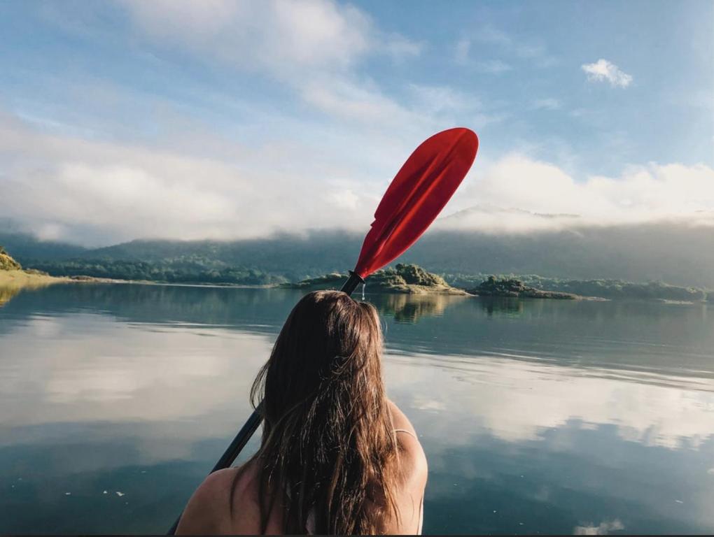 a woman on a paddle boat in the water at Rukgala Retreat in Digana