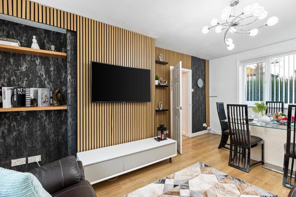 a living room with a tv on a wall at Comfy 3Bedroom Manchester Getaway in Manchester