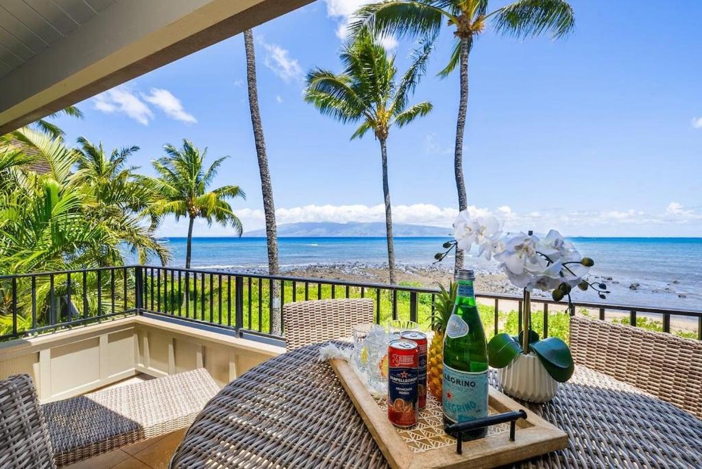 une table sur un balcon avec vue sur la plage dans l'établissement Kahana Village 32 · KHV 32 Direct Oceanfront Views Remodeled 2BD, à Kahana