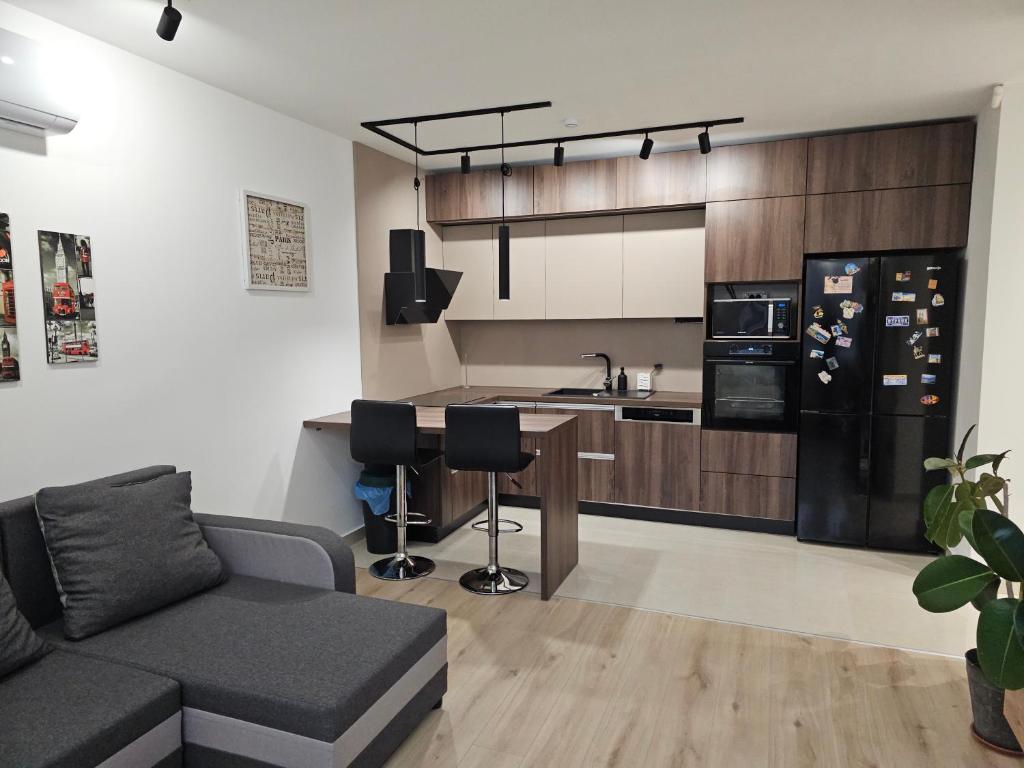 a living room with a couch and a kitchen at Szilvási's Smart Apartman in Eger
