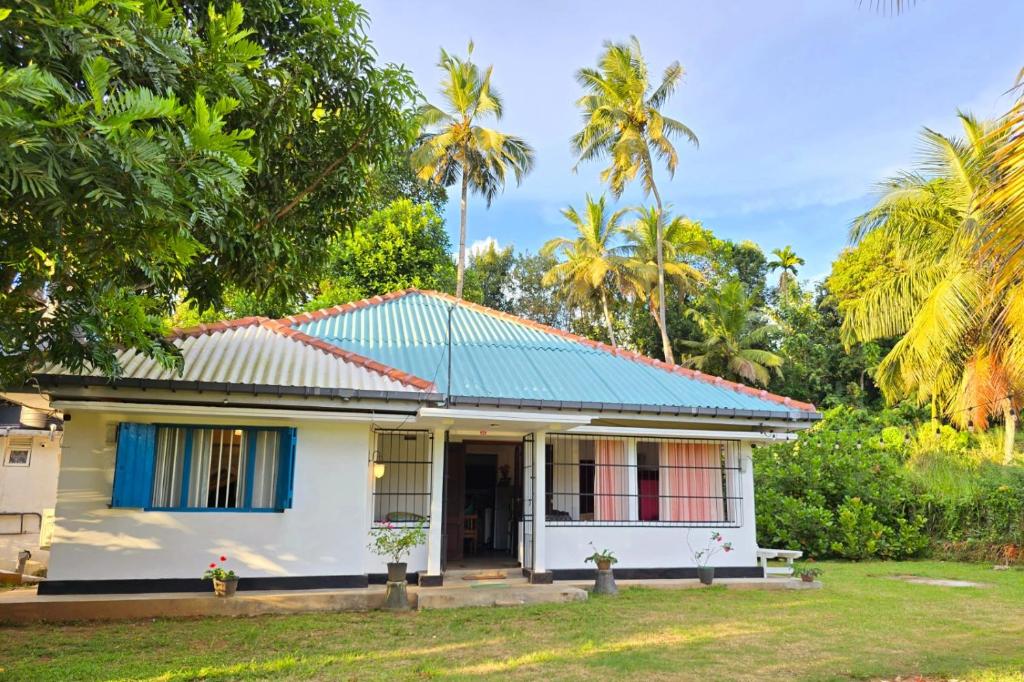une petite maison blanche avec un toit bleu dans l'établissement Villa Tamarind Shade - Talalla, à Talalla South