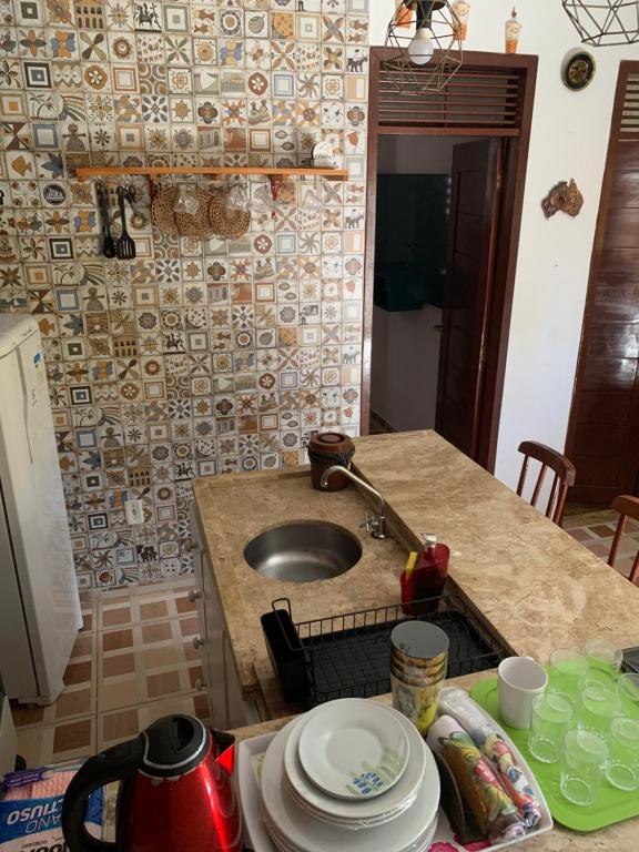 eine Küche mit einer Spüle und einer Arbeitsplatte mit Tellern in der Unterkunft Duplex praia de camarupim in Nísia Floresta