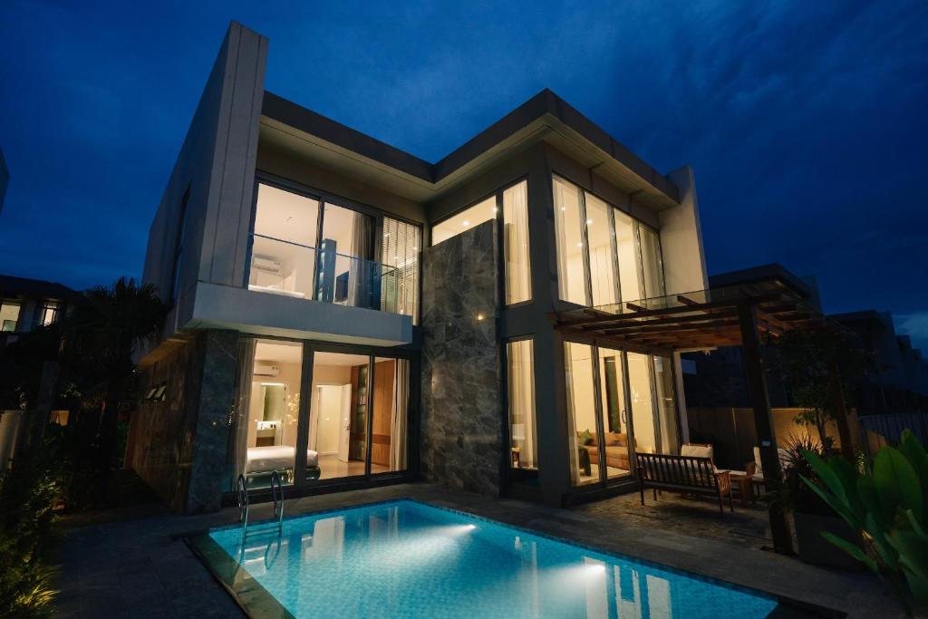 a villa with a swimming pool at night at TRON Villa - Regal Victoria Luxury BT9-09 in Dien Ban