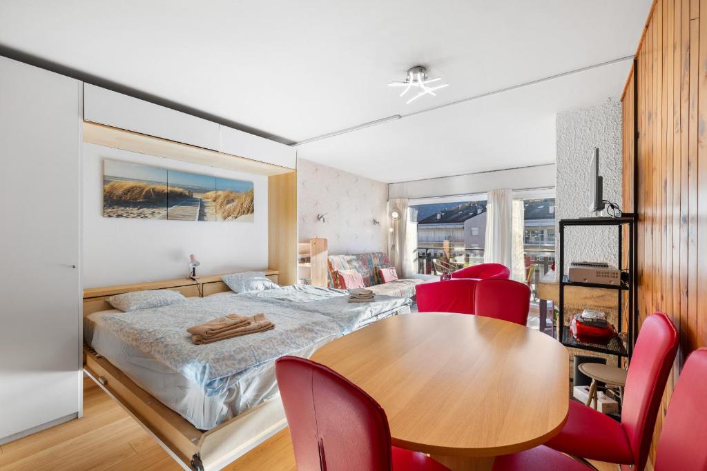 a bedroom with a bed and a table and chairs at Les Bouleaux D1 - 2-4 pers - centre station in Nendaz