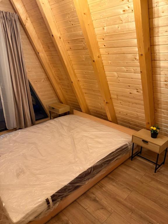 een bed in een kamer met een houten plafond bij Dominic A Frame in Fundata