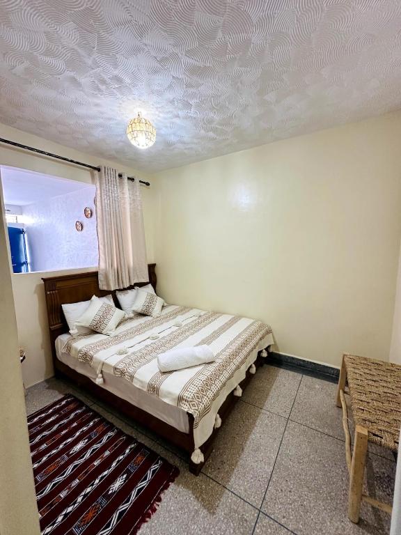 a bedroom with a bed in a room with a ceiling at Casa Wavy in Taghazout