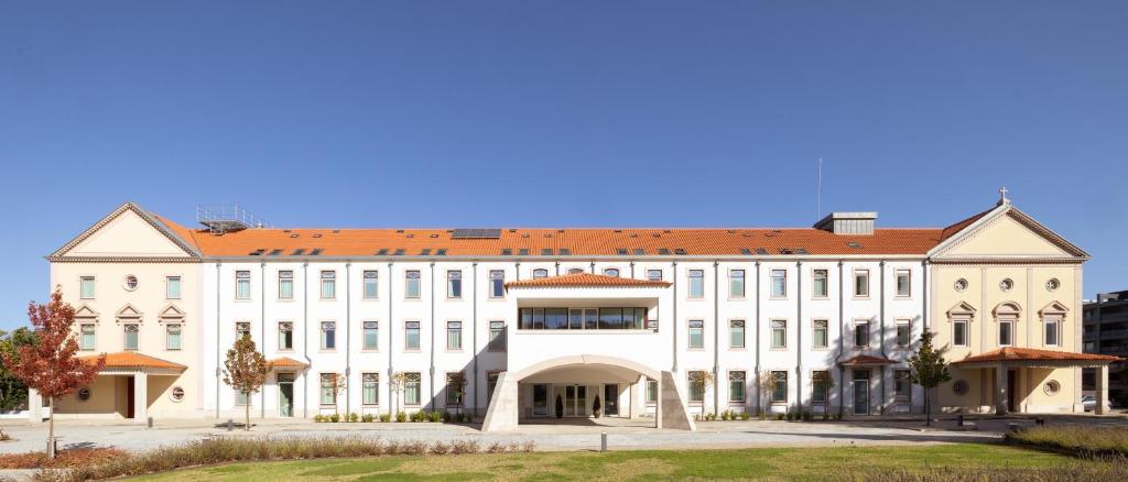 a large white building with a red roof at Stella Braga Aparthotel in Braga