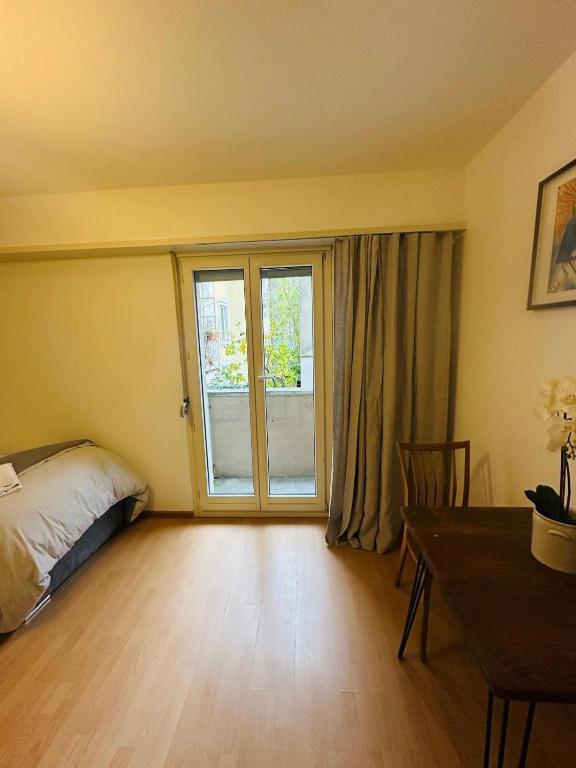 a bedroom with a bed and a table and a window at Hostel City Basel 366 in Basel