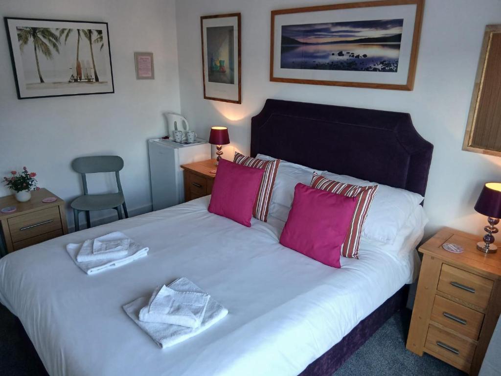 ein Schlafzimmer mit einem großen weißen Bett mit rosa Kissen in der Unterkunft The Gallery in Lancing