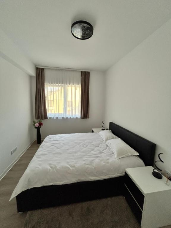 ein Schlafzimmer mit einem großen Bett und einem Tisch in der Unterkunft Noir Suite in Şelimbăr