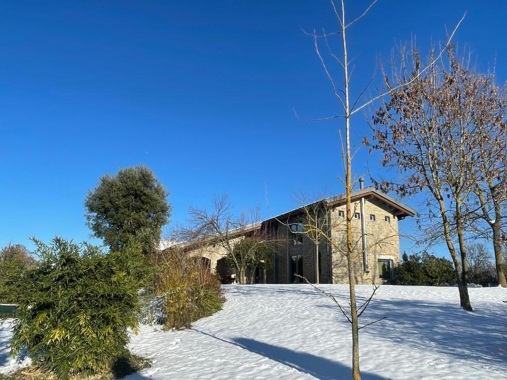 a house in the snow with a tree in front of it at CA' SAN LUISS in Cerretto Langhe