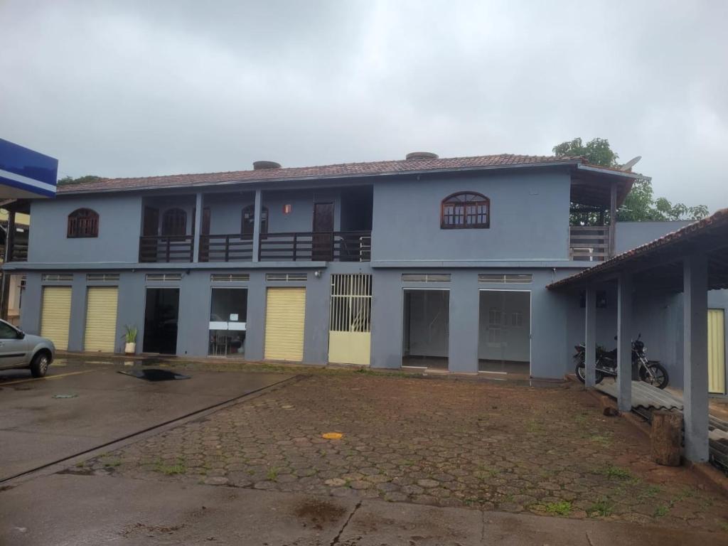 a blue and white building with a parking lot at Pousada Cachoeira in Itambé do Mato Dentro