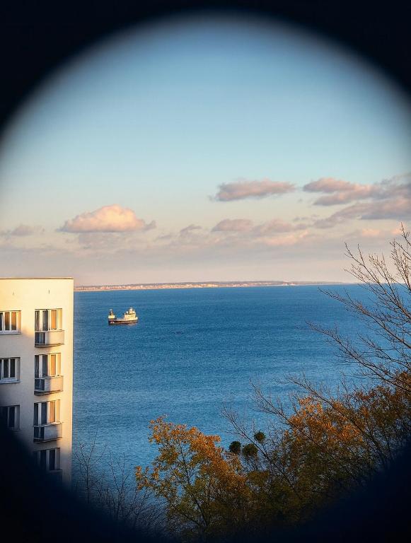 a boat in the water next to a building at Apartament Horizon z widokiem na morze in Gdynia