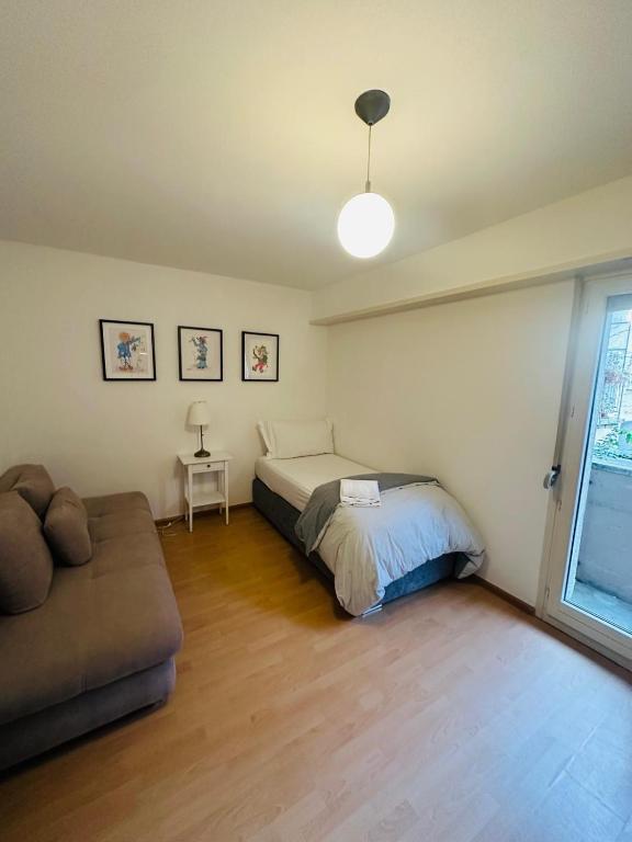 a bedroom with a bed and a couch in it at Hostel City Basel 389 in Basel
