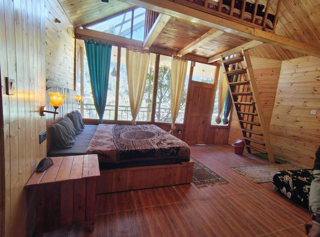 a bedroom with a bed in a wooden cabin at The Cedar Nook Tree House in Jibhi