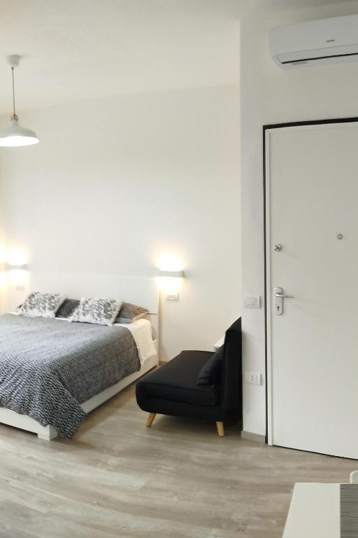 a bedroom with a bed and a black chair at Town Center Apartment in Cagliari