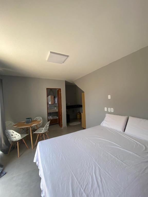 une chambre avec un lit et une table avec des chaises dans l'établissement AnaManô Flat térreo, à São Miguel dos Milagres