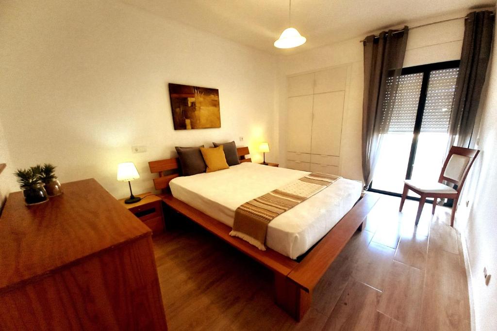 Un dormitorio con una cama grande con suelo de madera. en Abertura Mar Zen, en Cavacos