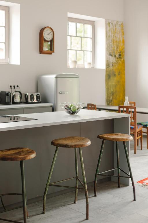 a kitchen with a counter and two stools at LOFT Köveskál in Köveskál