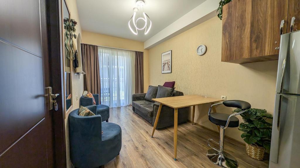 ein Wohnzimmer mit Tisch und Couch in der Unterkunft Krystal Resort Apartment A108 in Bakuriani